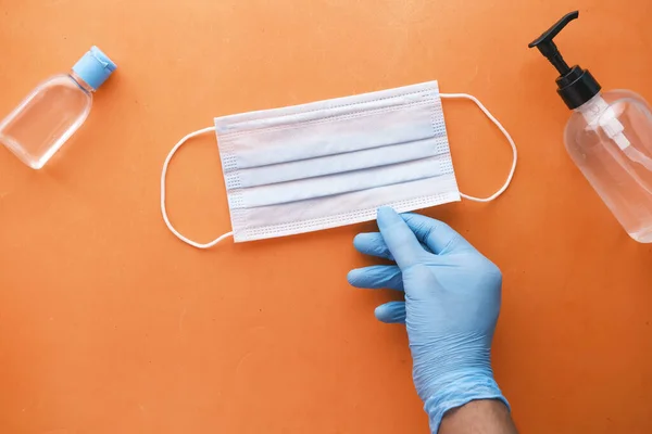 Medico mano in guanto medico che tiene maschera protettiva chirurgica, primo piano — Foto Stock