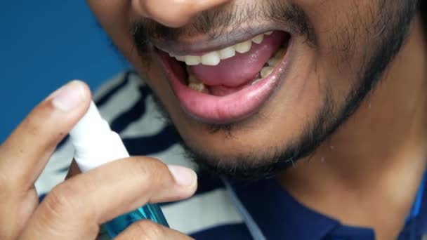 Hombre joven aplicando aerosol de respiración fresca — Vídeo de stock