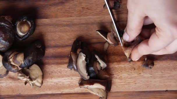 Kvinnor hand skära rå champignon svamp på en hackbräda på bordet — Stockvideo