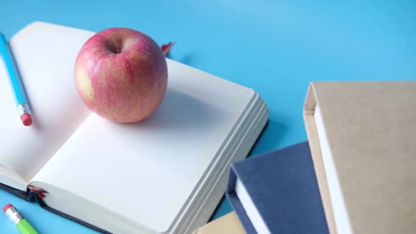 Concepto negro a la escuela con manzana en el bloc de notas en la mesa. — Vídeos de Stock