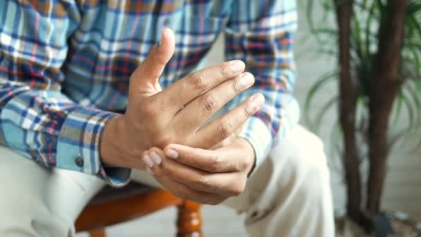 Omul suferă de durere în mână în timp ce stă așezat — Videoclip de stoc