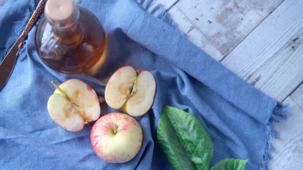 Vinagre de maçã em garrafa de vidro com maçã verde fresca na mesa — Vídeo de Stock