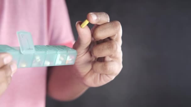 Mans hands taking medicine from a pill box — Stock Video