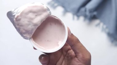 Plastik bir kabın içinde taze yoğurt tutuyordu. 