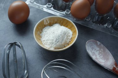 Siyah arkaplanda malzemeler pişiriliyor,