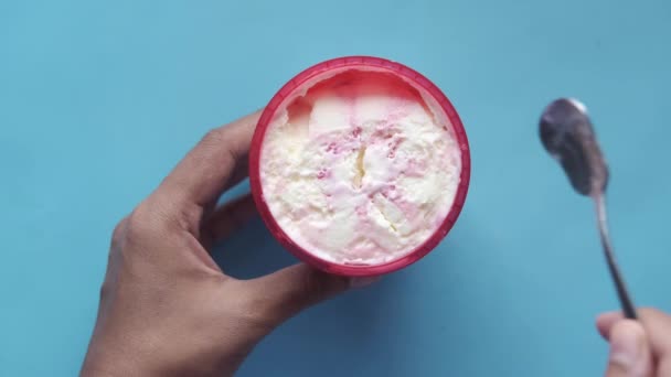 Recogiendo helado sabor vanila con una cuchara en un recipiente — Vídeo de stock