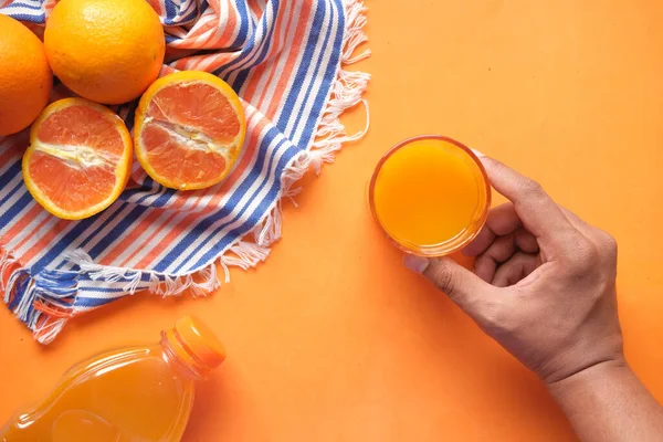 Vista superior de la celebración de un vaso de jugo de naranja — Foto de Stock