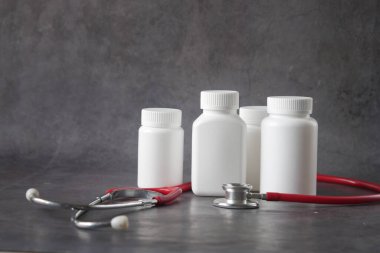 Siyah üzerine bir sürü ilaç kutusu ve steteskop. 