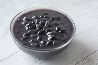 Masadaki bir kasede siyah fasulye taneleri .