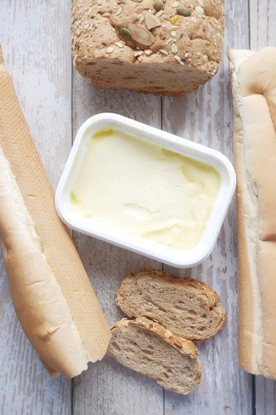 Plátek másla a celozrnného chleba na sekané desce — Stock fotografie