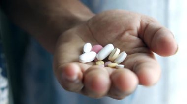 İlaç kutusundan dökülen ilaçlı adam eli. 