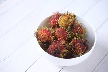 Masadaki kasede bir yığın Rambutan. 