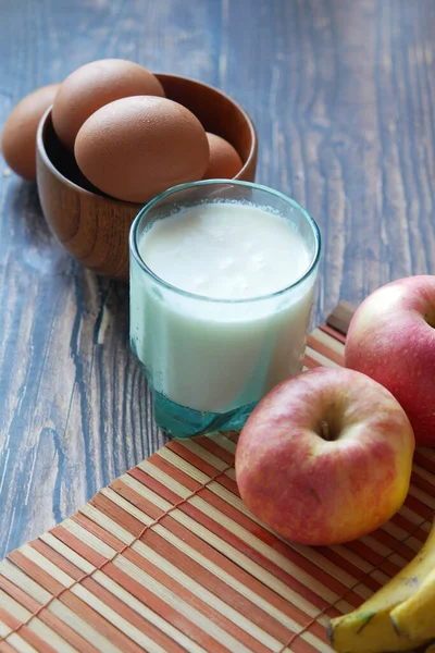 Sano concetto di snack con latte, uova e mela in tavola. — Foto Stock