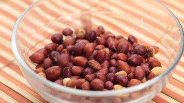 İşlenmiş bezelye kuruyemişleri masanın tepesindeki kasede düşüyor. .