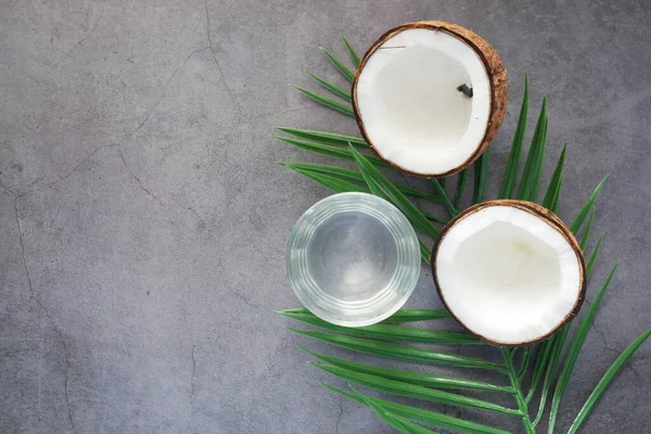 Plak verse kokosnoot en glas kokoswater op tafel — Stockfoto