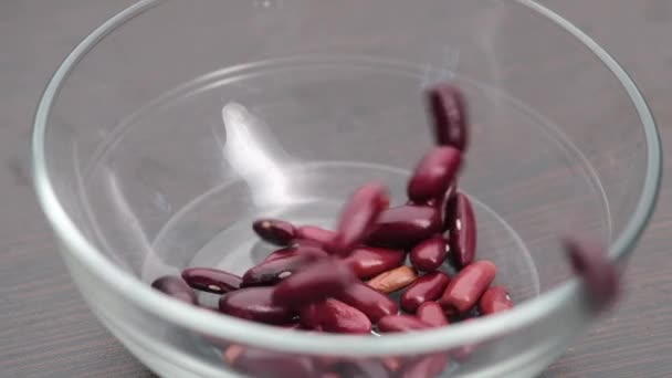 Slow motion of dropping red kidney bean in a bowl on table . — Stock Video