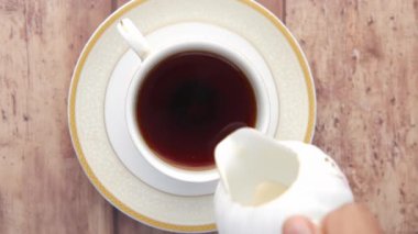 Sütü çayla bardağa dolduruyorum. ,