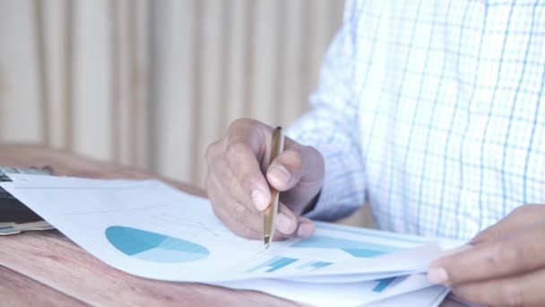 Mann Hand mit Stift analysiert Balkendiagramm auf Papier — Stockvideo