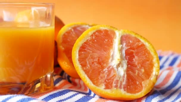 Vidro de suco de laranja e frutas no fundo de cor — Vídeo de Stock