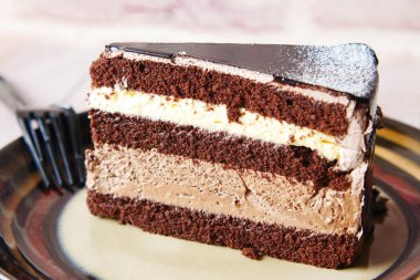 Masadaki tabakta çikolatalı ve kremalı pasta. 