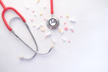  Beyaz arka planda tıbbi ilaçlar ve steteskop. 