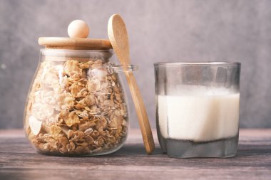 Müsli ve kurutulmuş meyve kavanozunda bir bardak süt.,