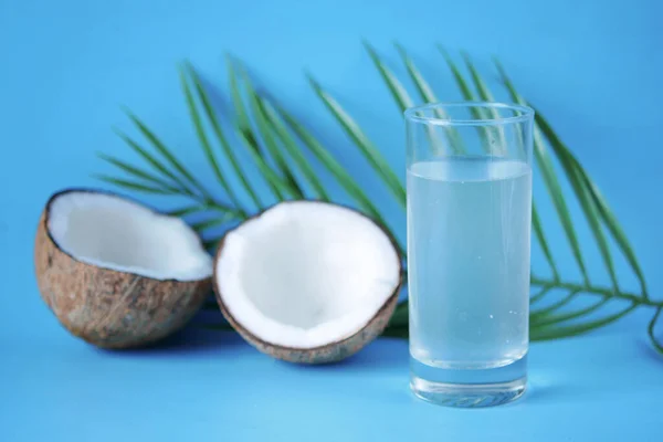 Fatia de coco fresco e vidro de água de coco na mesa — Fotografia de Stock