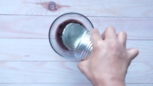 Pouring black bean in a bowl on table . — Stock Video