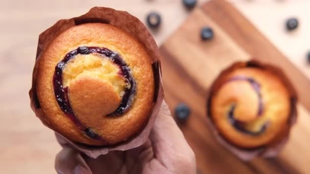 Mano sosteniendo muffin de arándano de cerca — Vídeos de Stock