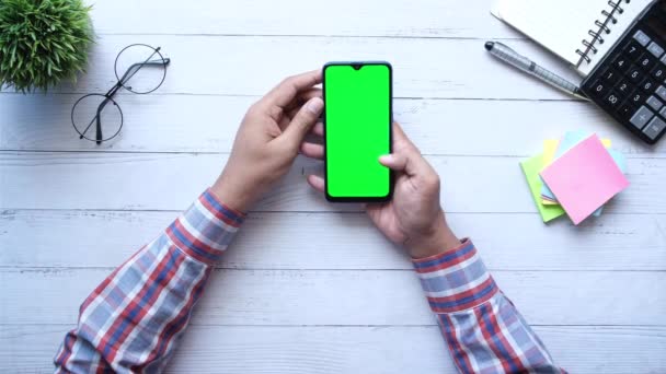 Молодой человек руку со смартфоном на рабочем столе — стоковое видео