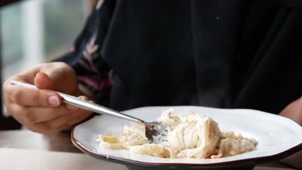 Young women eating ream and herb pasta on table — Stock Video