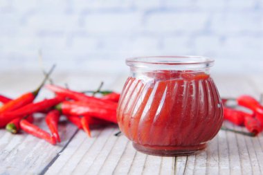 Kırmızı biber ve domates sosu masada küçük bir kavanozda. 