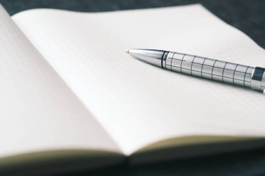 Siyah arkaplan üzerine f açık not defteri ve kalemi kapat 