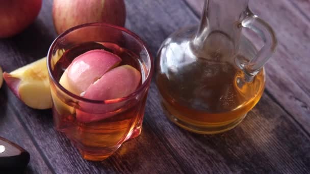 Ξύδι μήλου σε γυάλινο μπουκάλι με φρέσκο πράσινο μήλο στο τραπέζι — Αρχείο Βίντεο