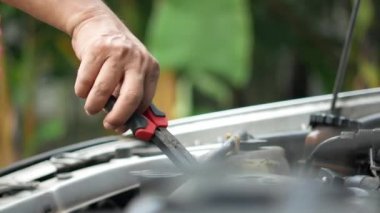 Çalışıyor ve araba motorunu tamir ediyor .