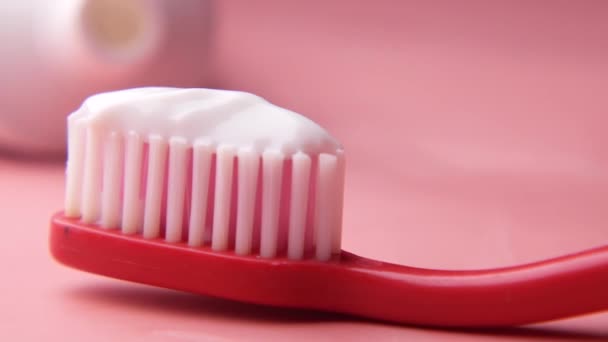 Pembe arka planda yapıştırıcılı diş fırçası — Stok video