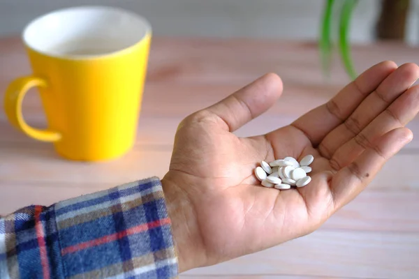 Männerhand mit Medikament aus Pillenbehälter verschüttet — Stockfoto