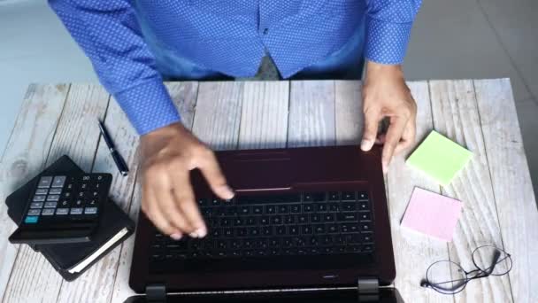 Vista dall'alto del giovane che apre un computer portatile e inizia a lavorare — Video Stock