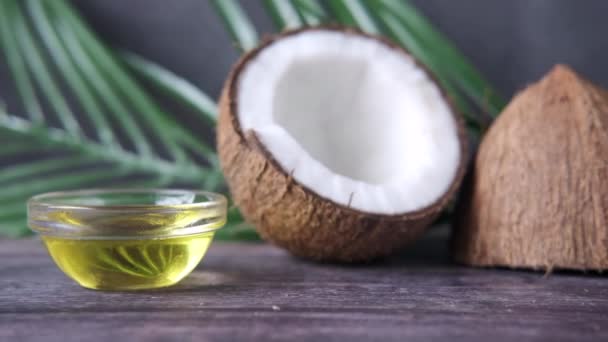 Slice of fresh coconut and bottle of oil on a table — Stock Video