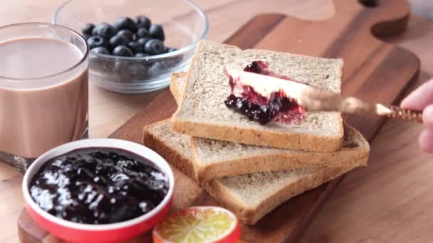 Blauwe bessenjam op brood op tafel, — Stockvideo