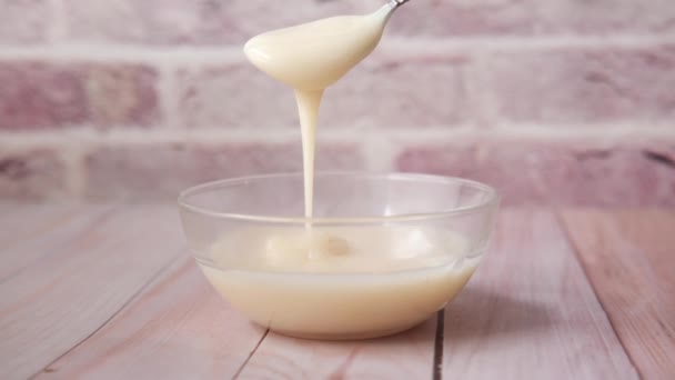 Gecondenseerde melk in een kom close-up, — Stockvideo