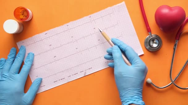 Mano del médico en guantes médicos analizando el diagrama cardiovascular. — Vídeo de stock