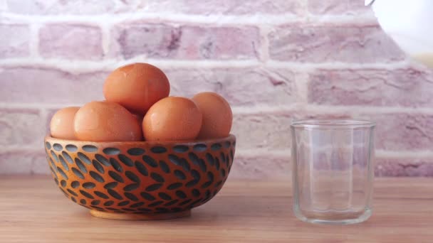 Huevos en un arco y verter la leche en una mesa de vidrio — Vídeos de Stock