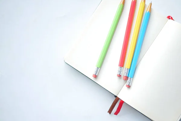 Zavřít barevné tužky na poznámkovém bloku — Stock fotografie