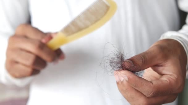 Мужчина держит свой список волос крупным планом — стоковое видео