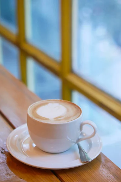 Uma xícara de café tarde com design de forma de flor no topo no café — Fotografia de Stock