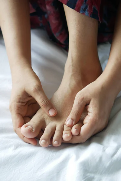 Primer plano en los pies de las mujeres y masaje de manos en el lugar de lesión. — Foto de Stock