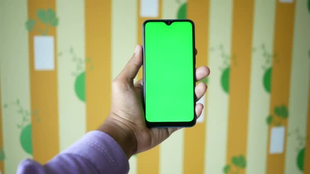 Primer plano de la mano del hombre joven utilizando el teléfono inteligente con pantalla verde — Vídeo de stock