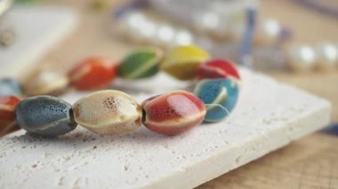 Sanatsal olarak sıralanmış kil ve diğer malzemelerden yapılmış renkli boncukları görüntüle.