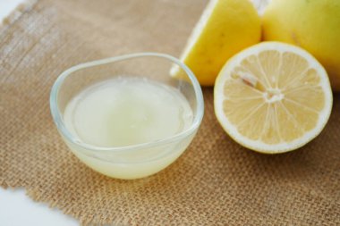 Limon suyu, çuval bezinde yarı yarıya taze limonların yanında bir kasede..
